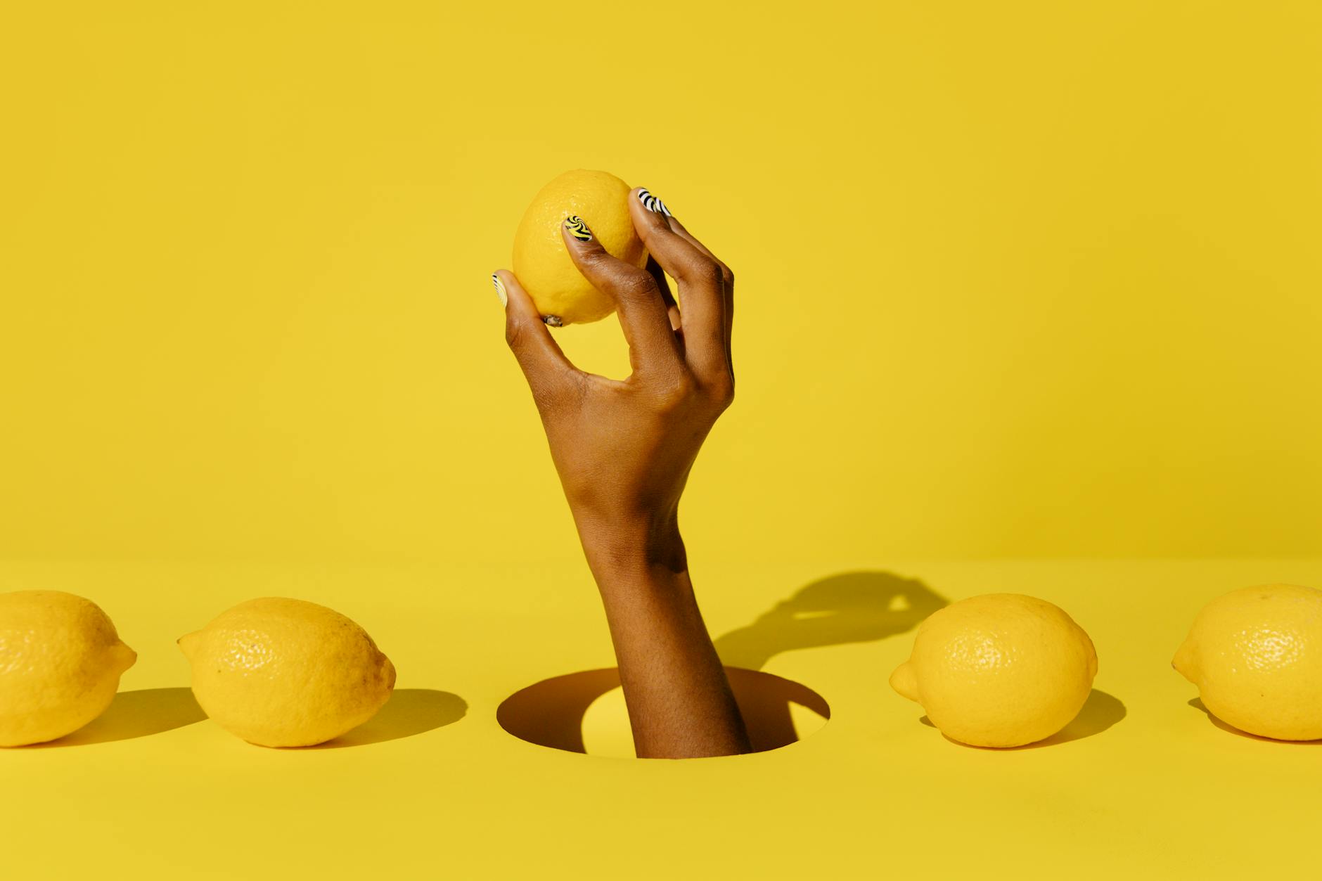 A lemon held against a bright yellow background, symbolizing fresh sensation and citrus energy
