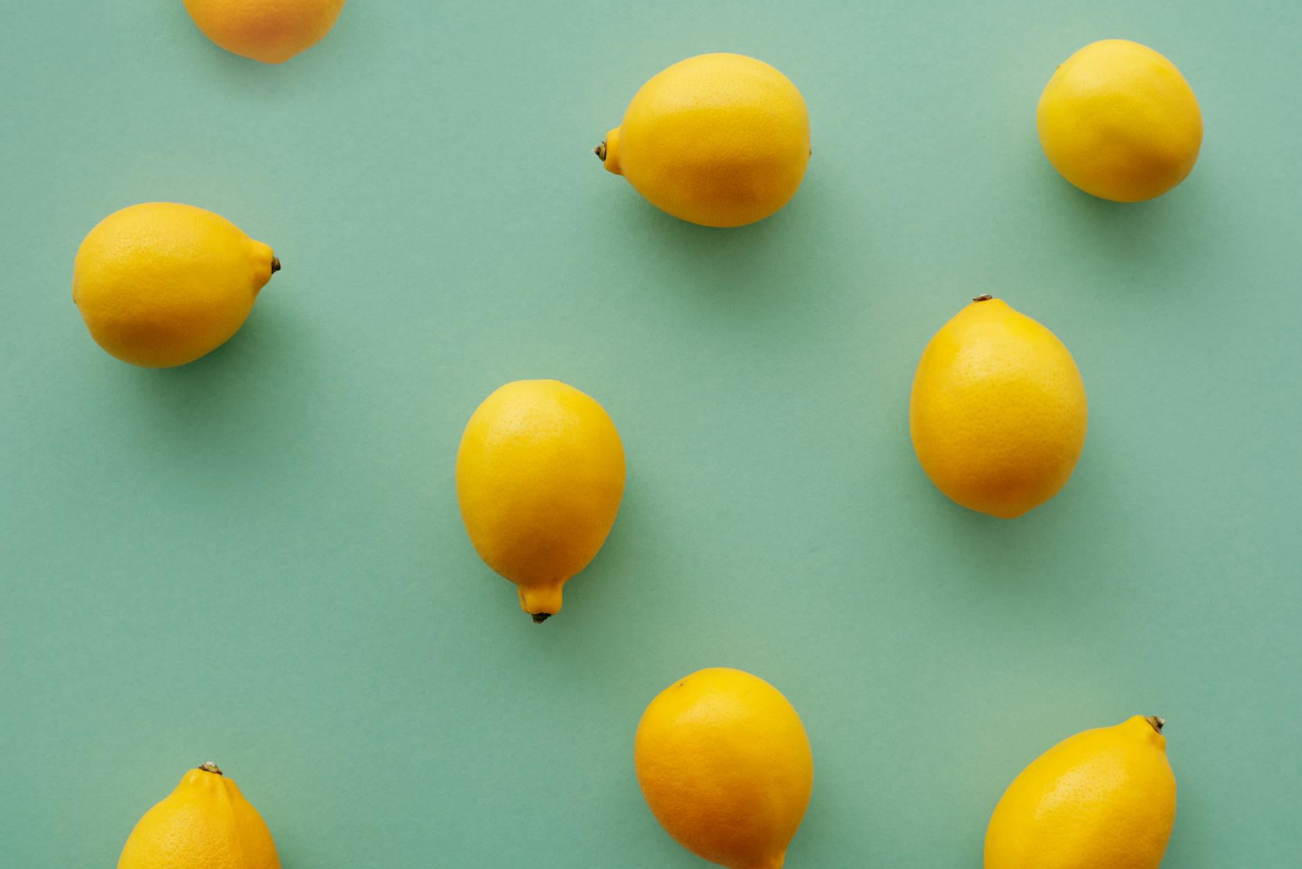 Bright yellow lemons arranged on a pastel background, symbolizing fresh pleasure and vitality
