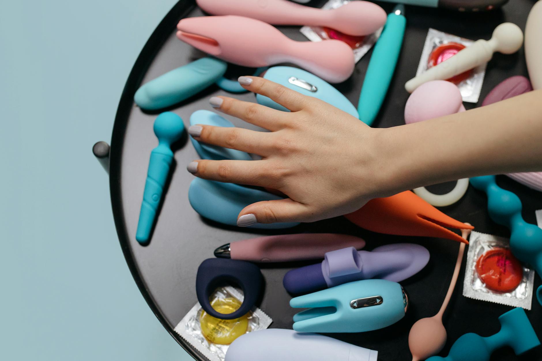 A woman holding a vibrator with books nearby, symbolizing reclaiming personal intimacy and healing