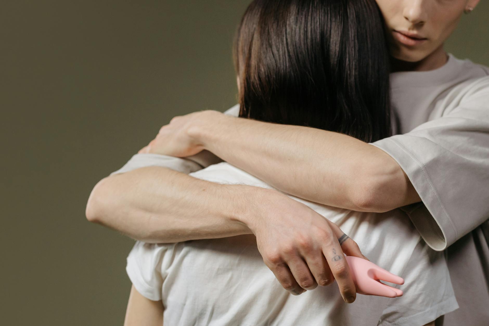 Two hands held together in intimate connection, symbolizing emotional healing and self-compassion