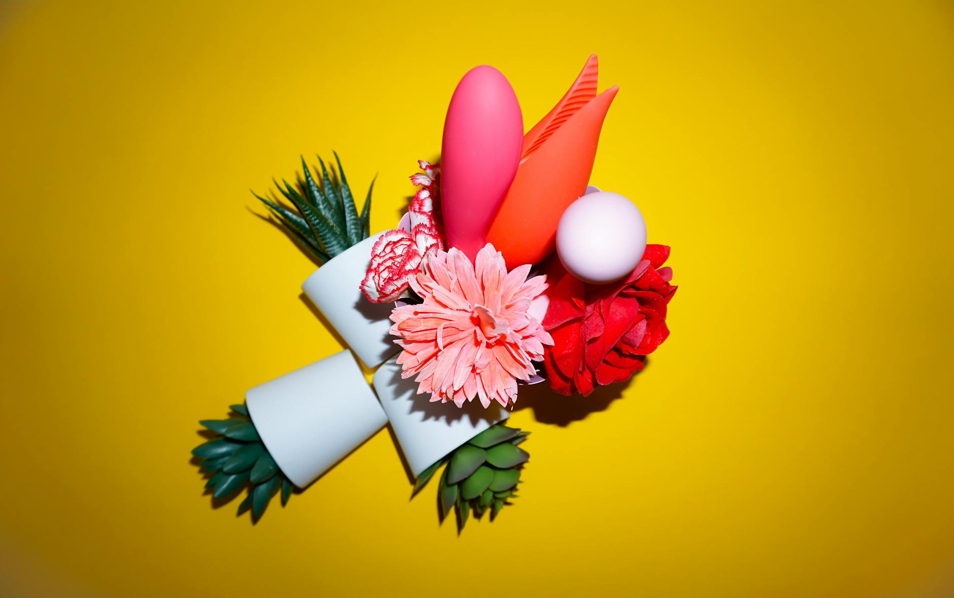 Hands holding pastel-colored silicone toys on a neutral background