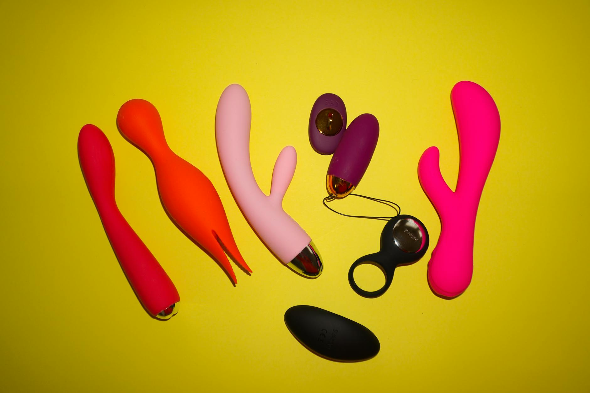 A young couple standing together indoors, holding a blue vibrator, symbolizing modern intimacy and shared pleasure exploration.
