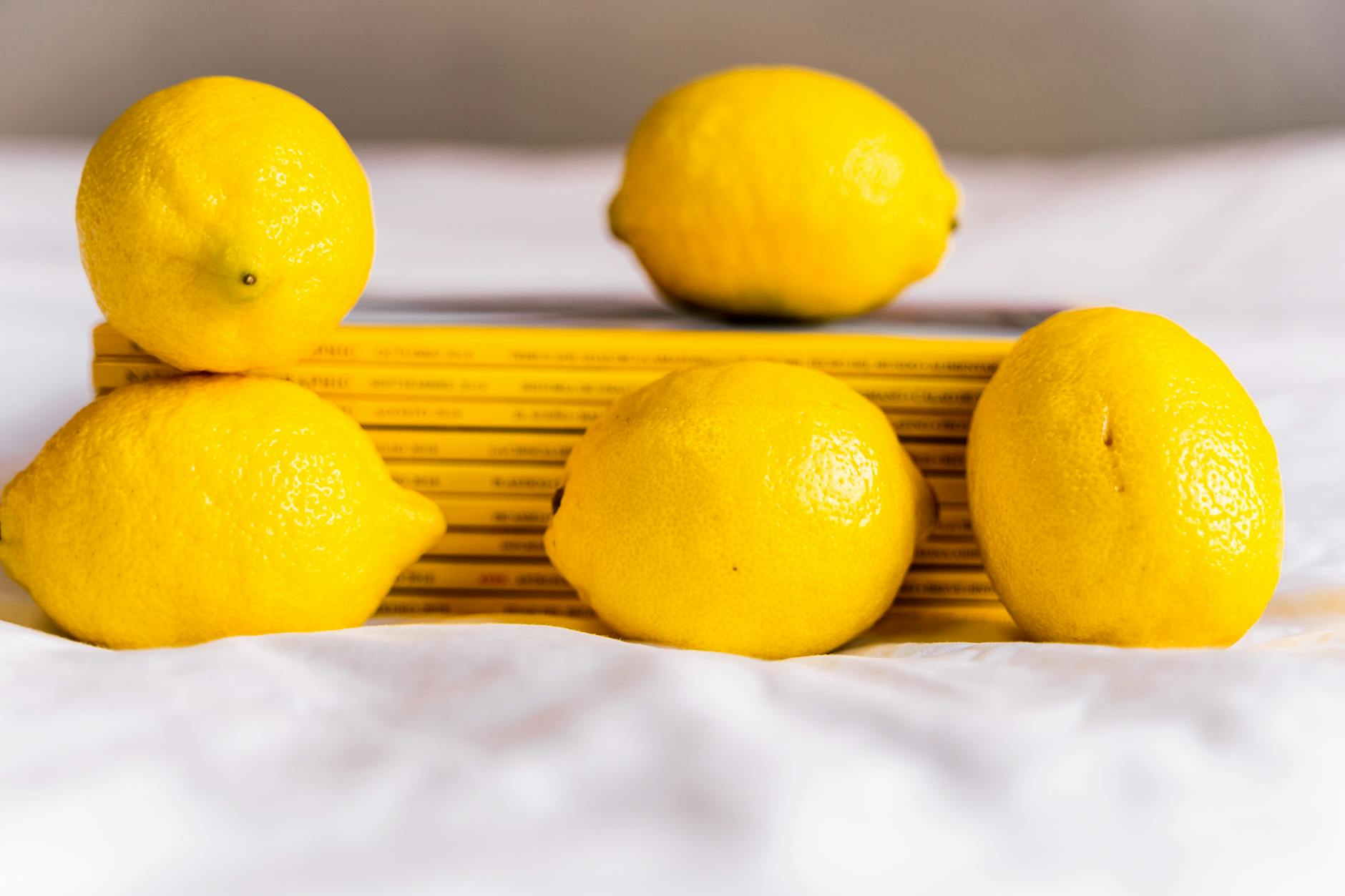 A blue vibrator surrounded by fresh citrus and flowers on a bright yellow background
